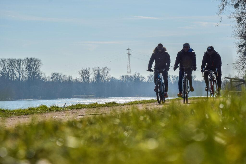 Trois jeunes sur des vélos au bord de l'eau